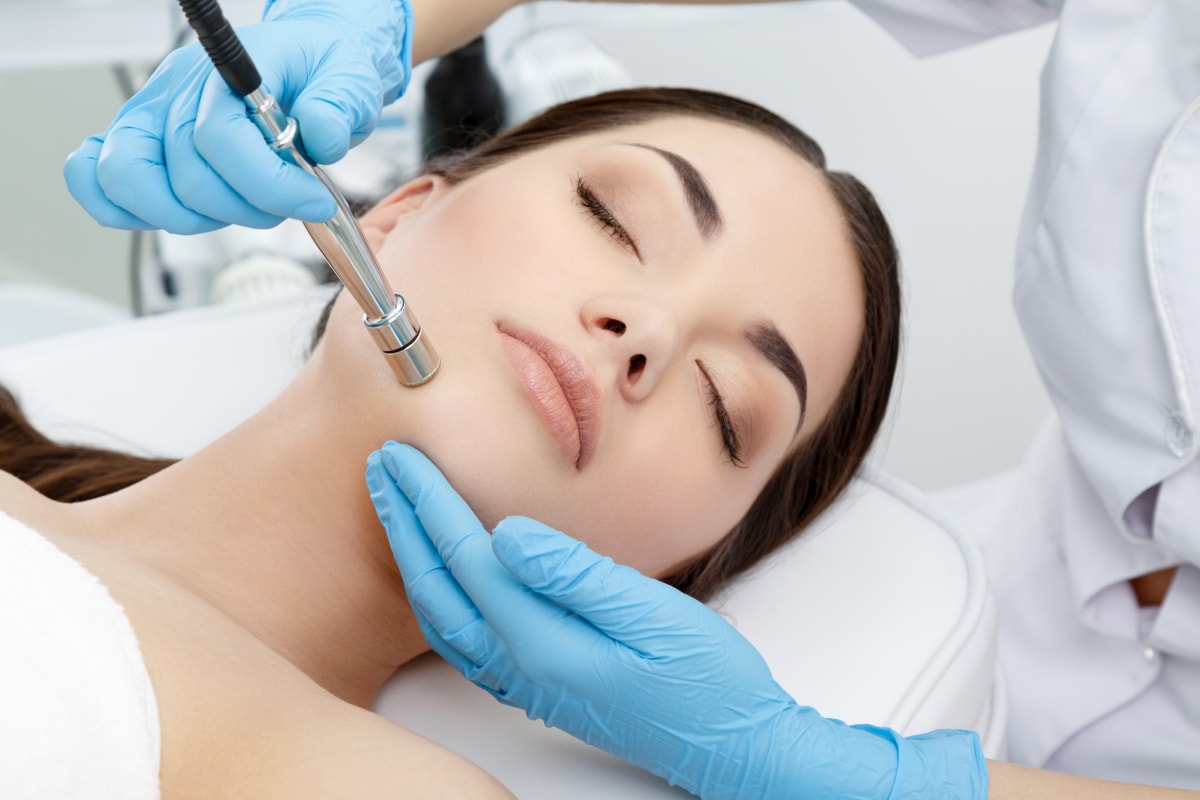 Mikrodermabrasion einer Gesichtshaut mit dem Behandlungsgeraet